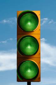 All green traffic light with a blue sky.